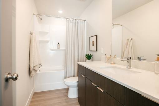 A white bathroom with a toilet, sink, and shower.