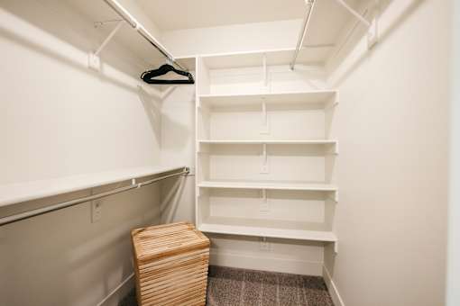 A white closet with a hanger and a basket.