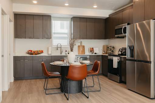 A modern kitchen with a table and chairs.