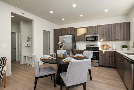 A modern kitchen with a dining table set for two.