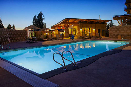 a swimming pool in front of a hotel at dusk