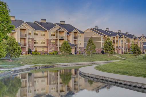 A row of houses with a pond in front.
