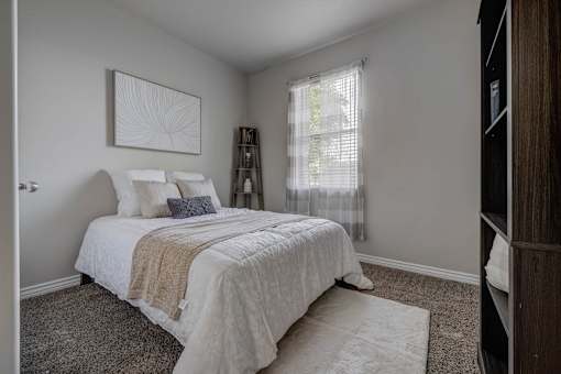 A bedroom with a large bed and a painting on the wall.