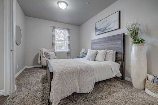 A bedroom with a large bed and a smaller bed in the background.