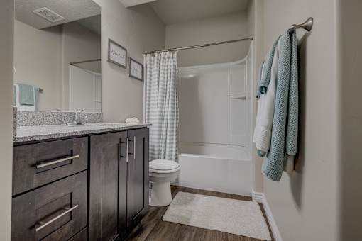 A bathroom with a toilet, sink, and shower.