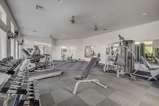A spacious gym with a variety of equipment including treadmills, weights, and exercise machines.