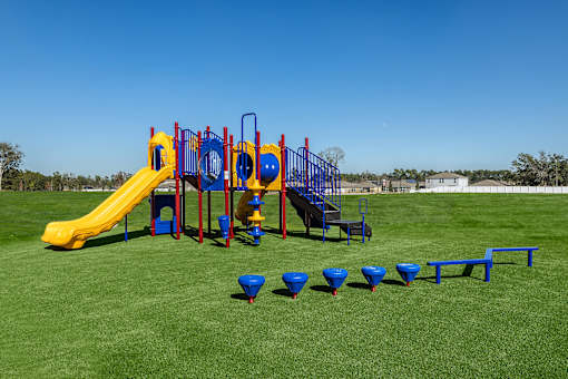 A playground with a yellow slide and blue and red play structures.