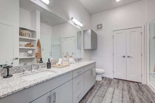 Primary bathroom with dual sink vanity and large mirror
