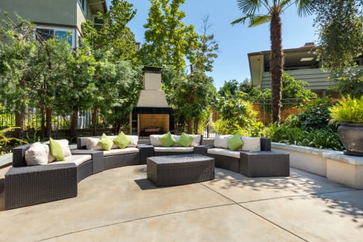 a seating area with couches and pillows in front of a fire at Orange Grove Circle, Pasadena, CA