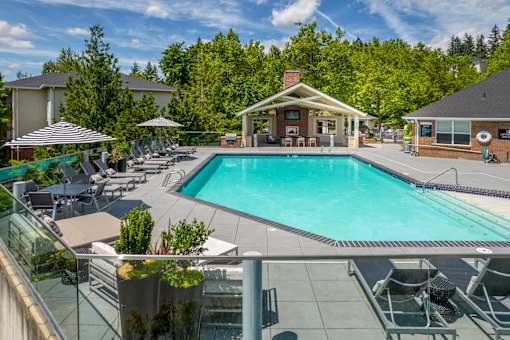 A large swimming pool surrounded by lounge chairs and umbrellas.
