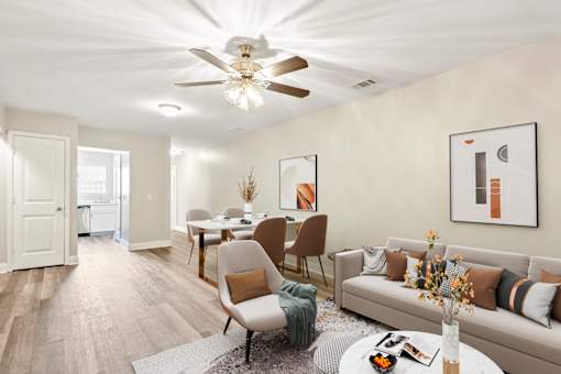 A living room with a couch, chairs, and a dining table.