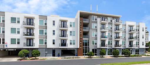 Apartment building with balconies and doors.