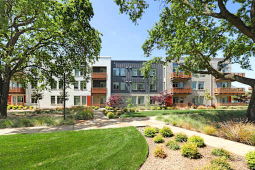 A row of modern houses with green lawns in front.