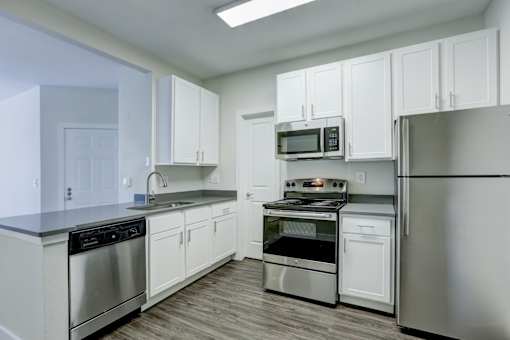 A kitchen with white cabinets and stainless steel appliances.