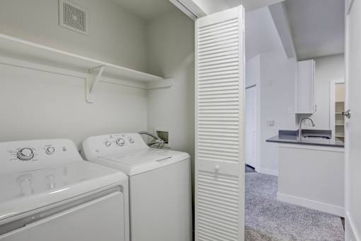 A white laundry room with a washer and dryer.
