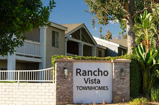 A sign that says Rancho Vista Townhomes in front of a building.