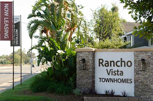 A sign for Rancho Vista Townhomes is displayed in front of a building.