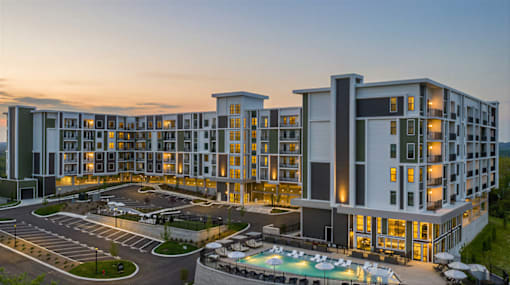 A large hotel building with a pool in front.