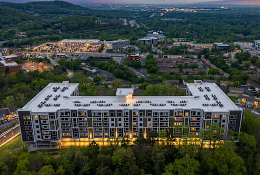 A large building with a lot of windows is surrounded by trees.