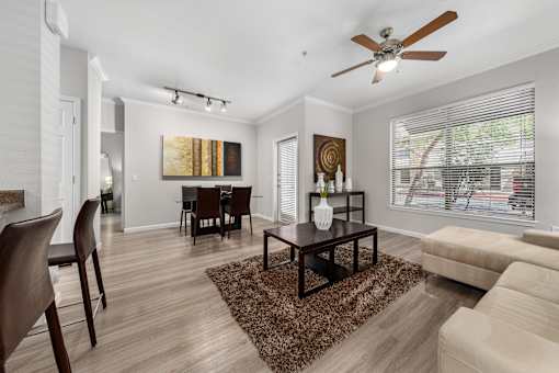 A living room with a brown rug and a brown coffee table.