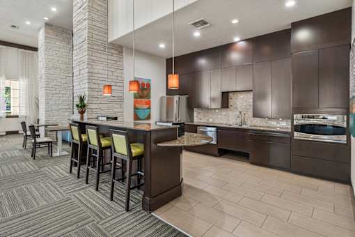 A modern kitchen with a bar area and a dining table.