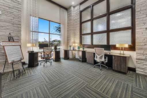 A business center with a sign, chairs, and desks.