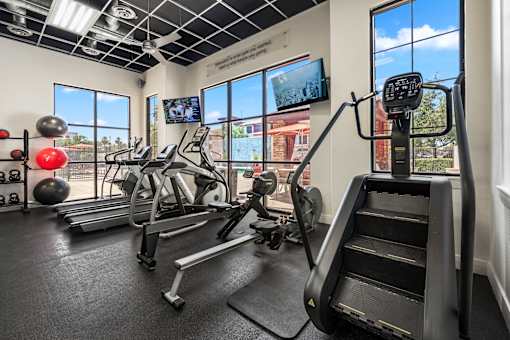 A gym with a treadmill, exercise bike, and other equipment.