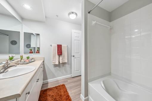 A white bathroom with a white tub and a white sink.
