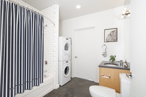 Bathroom with a washing machine and a toilet