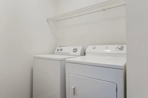 Two white washing machines in a laundry room.