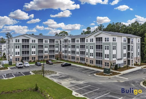 a large apartment building with cars parked in a parking lot
