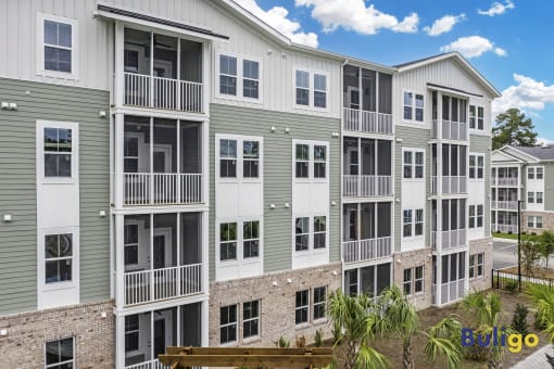 an exterior view of an apartment building with a bench in front of it