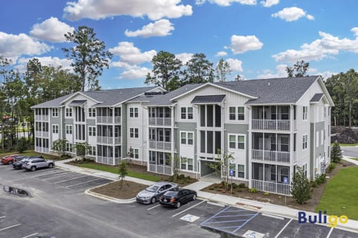a large apartment building with cars parked in a parking lot