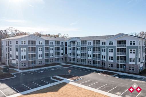 A large white building with a parking lot in front.