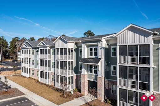 A row of townhouses with a clear blue sky above them.