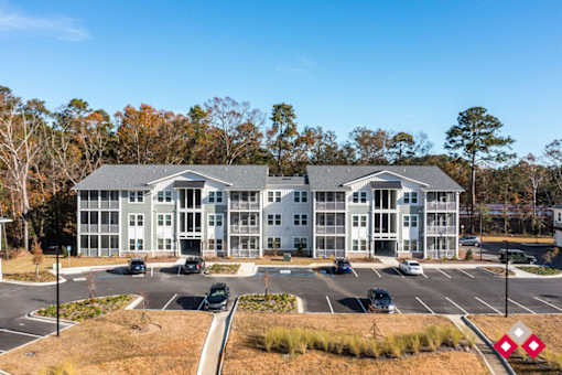 A large white building with a parking lot in front.