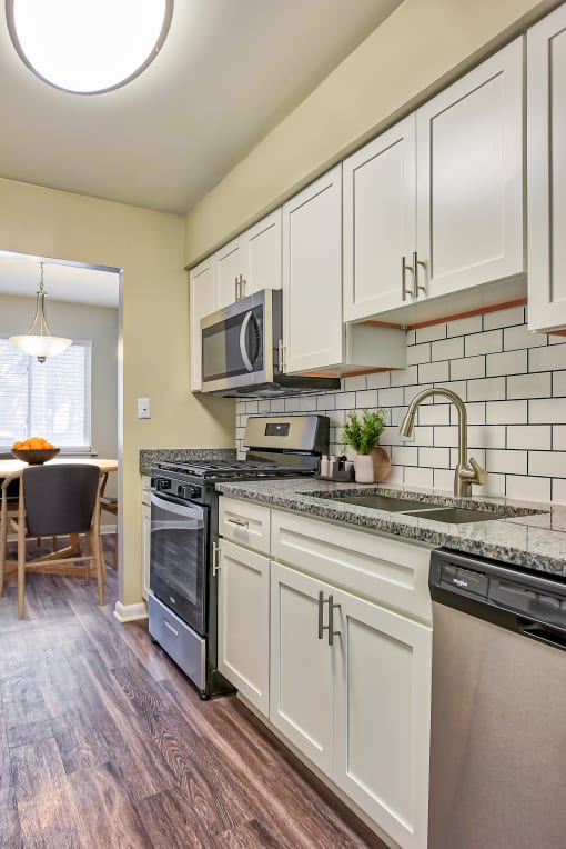 a kitchen with white cabinets and black appliances