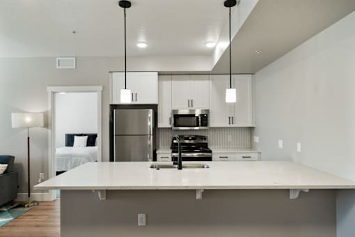 a kitchen with a large island and a stainless steel refrigerator
