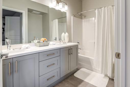 A bathroom with a white shower curtain and a white sink.