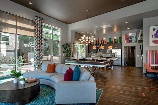 A modern living room with a curved sofa and a round coffee table.