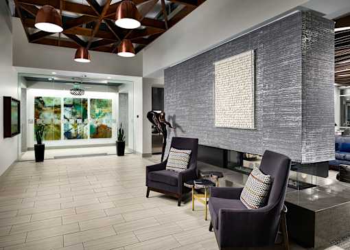 A modern living room with a grey sofa and a grey armchair.