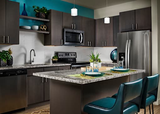 A modern kitchen with a table set for two.