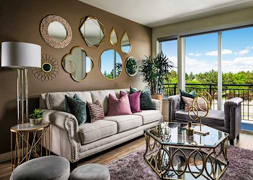 A living room with a white couch, a glass table, and a purple rug.