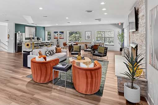 A living room with a white couch and orange chairs.