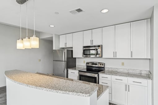 a kitchen with white cabinets and granite counter tops