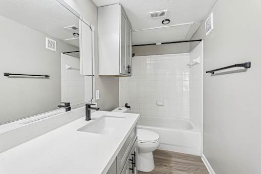 A white bathroom with a toilet, sink, and bathtub.