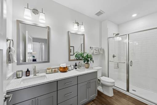 A bathroom with a white toilet, sink, and mirror.