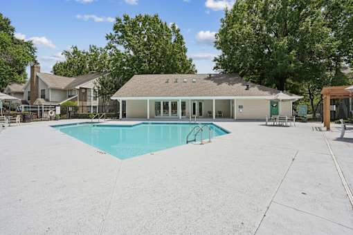 A large swimming pool in front of a house.