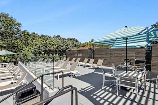A sunny day at the outdoor pool area with sun loungers and a shade structure.