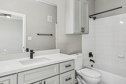 A white bathroom with a sink, toilet, and bathtub.